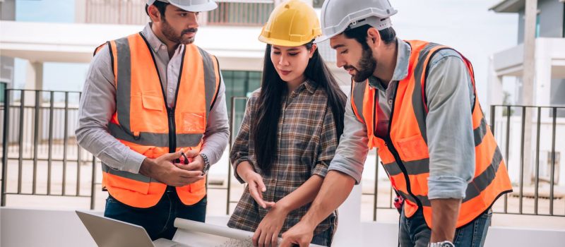 civil-engineer-construction-worker-architects-wearing-hardhats-safety-vests-are-working-together-construction-site-building-home-cooperation-teamwork-concept (1)